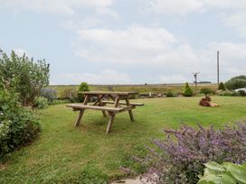 A garden with a picnic table and flowers at Wethercote Cottage in Old Byland near Helmsley