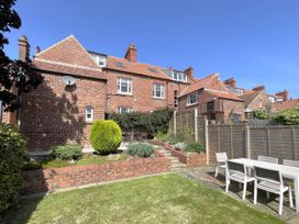 A garden with a table and chairs at Sterling House in Robin Hood's Bay