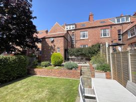 A garden with a table and chairs next to a house at Sterling House Robin Hood's Bay