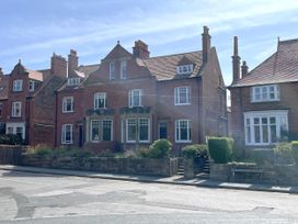A brick house with a garden and multiple windows at Sterling House in Robin Hood's Bay