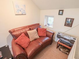 A living room with a sofa and boombox at Wood Cottage in Kendal