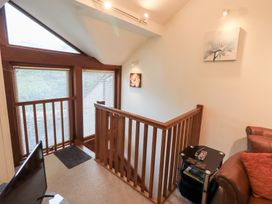A staircase with a railing and a small table at Wood Cottage Kendal