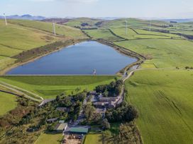 A lake surrounded by fields and buildings at Woodside Barn in Pennington near Ulverston