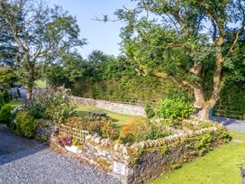 A garden with a stone wall and a picnic table at Woodside Barn Pennington near Ulverston