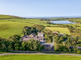 An aerial view of a property surrounded by fields and a pond at Woodside Barn Pennington near Ulverston