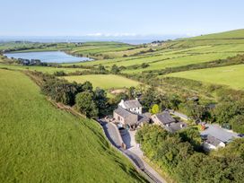A view of fields and a lake with buildings at Woodside Barn Pennington near Ulverston