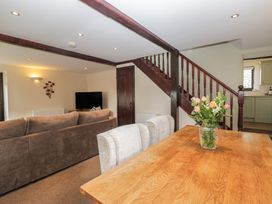 A living room with a sofa and dining table at Woodside Barn Pennington near Ulverston