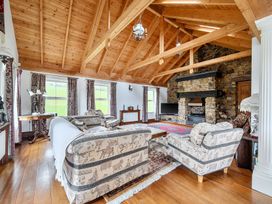 A living room with sofas, a coffee table, and a fireplace at Chapel Green in Polgooth