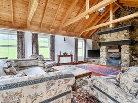 A living room with a sofa, coffee table, and fireplace at Chapel Green in Polgooth