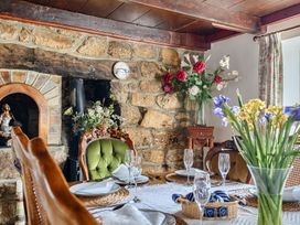A dining room with a table set for meals at Chapel Green in Polgooth