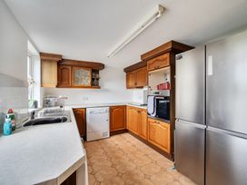 A kitchen with cabinets and appliances at Chapel Green in Polgooth