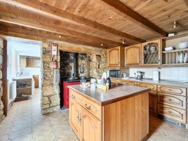 A kitchen with wooden cabinets and appliances at Chapel Green in Polgooth