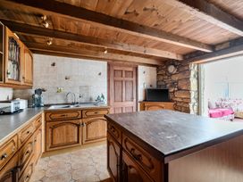 A kitchen with wooden cabinets and a sink at Chapel Green in Polgooth