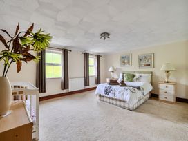 A bedroom with a bed and crib at Chapel Green in Polgooth