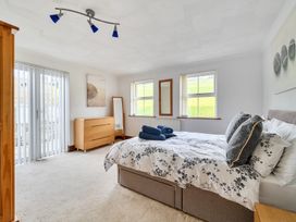 A bedroom with a bed and dresser at Chapel Green in Polgooth
