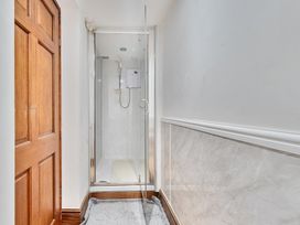 A bathroom with a shower and door at Chapel Green in Polgooth