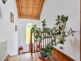 A hallway with a staircase and a plant at Chapel Green Polgooth