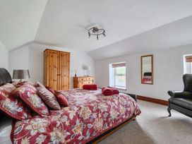 A bedroom with a bed and wardrobe at Chapel Green in Polgooth