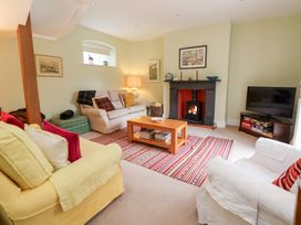 A living room with a fireplace and seating at Bryn Howell Stables Trevor near Llangollen