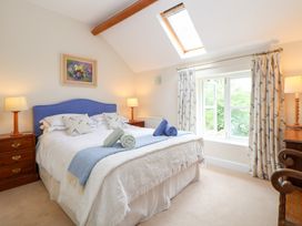 A bedroom with a bed, bedside tables and a window at Bryn Howell Stables Trevor near Llangollen