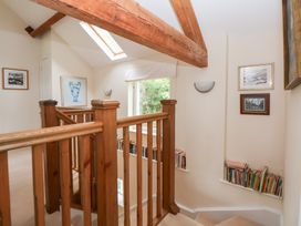 A hallway with a staircase and bookshelves at Bryn Howell Stables Trevor near Llangollen