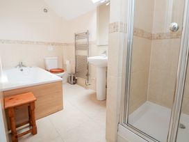 A bathroom with a bath tub, toilet, sink, shower, and towel warmer at Bryn Howell Stables in Trevor near Llangollen