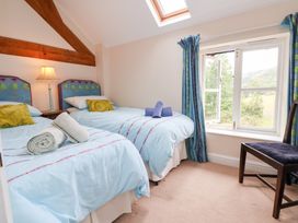 A bedroom with two beds and a window at Bryn Howell Stables Trevor near Llangollen