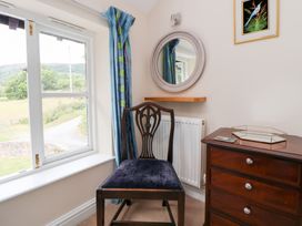 A bedroom with a chair near a window at Bryn Howell Stables in Trevor near Llangollen