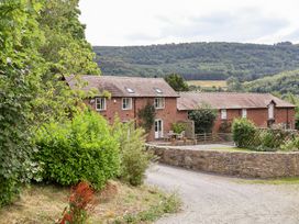 A building with garden and road near mountains at Bryn Howell Stables Trevor near Llangollen