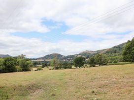 A field with trees and hills in the background at Bryn Howell Stables Trevor near Llangollen