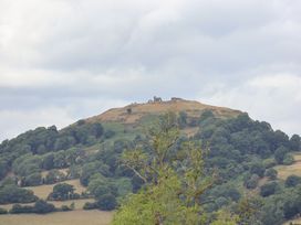 A hill with trees and ruins at Bryn Howell Stables Trevor near Llangollen
