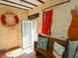 An entryway with a life ring and flag at Crow's Nest Cottage in Tynygongl near Benllech