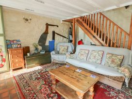A living room with a sofa and coffee table at Crow's Nest Cottage in Tynygongl near Benllech