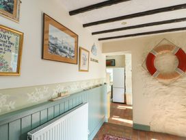 A hallway with wall art and a lifebuoy at Crow's Nest Cottage in Tynygongl near Benllech