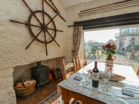 A dining room with a table set for a meal at Crow's Nest Cottage in Tynygongl near Benllech