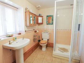 A bathroom with a sink, shower, and toilet at Crow's Nest Cottage in Tynygongl near Benllech