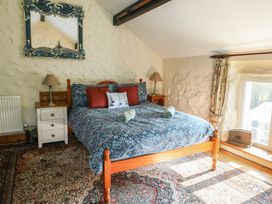 A bedroom with a bed and bedside table at Crow's Nest Cottage Tynygongl near Benllech