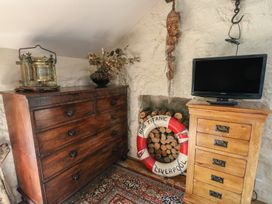 A bedroom with chest of drawers and television at Crow's Nest Cottage Tynygongl near Benllech