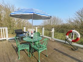 An outdoor seating area with a table and chairs at Crow's Nest Cottage in Tynygongl near Benllech