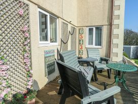 An outdoor seating area with chairs and a table at Crow's Nest Cottage Tynygongl near Benllech