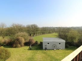 A garden area with a shed surrounded by trees at Crow's Nest Cottage Tynygongl near Benllech