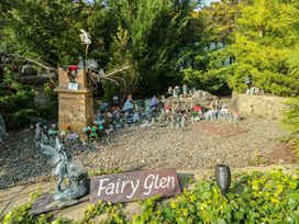 A fairy garden with decorative figures and plants at Crow's Nest Cottage Tynygongl near Benllech