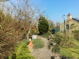 A garden with a pathway and plants at Crow's Nest Cottage in Tynygongl near Benllech