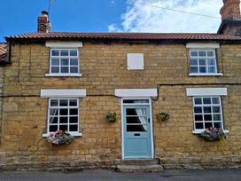 A stone cottage with flower pots and windows at Boundcliffe Farm in Allerston near Pickering
