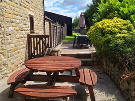 A garden with a wooden table and benches at Boundcliffe Farm in Allerston near Pickering