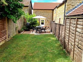 A garden with a table and chairs under an umbrella at Boundcliffe Farm in Allerston near Pickering