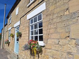 An exterior wall with flower pots and windows at Boundcliffe Farm in Allerston near Pickering