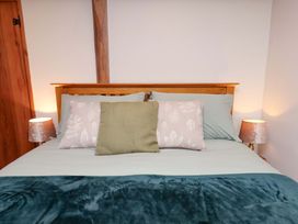A bed with pillows and lamps in a bedroom at Boundcliffe Farm Allerston near Pickering