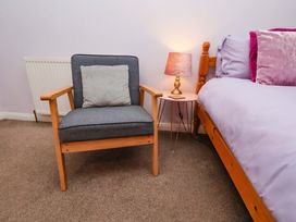 A bedroom featuring an armchair and bedside table at Boundcliffe Farm in Allerston near Pickering