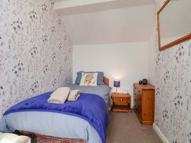 A bedroom with a bed, nightstand, and lamp at Boundcliffe Farm in Allerston near Pickering